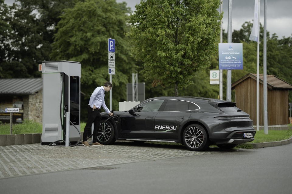 Mann lädt E-Auto