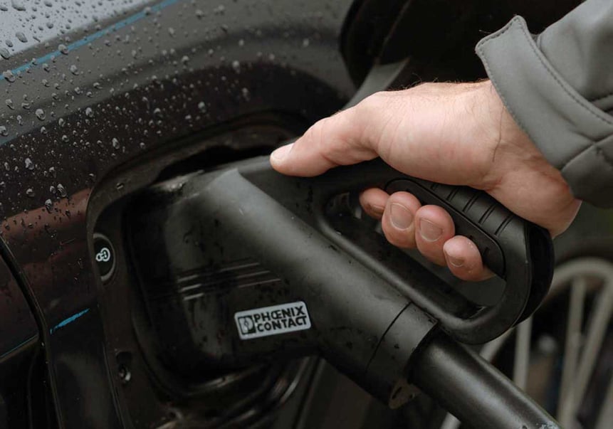 DC-Stecker steckt in schwarzem E-Auto