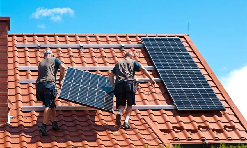 Solarpaneele werden auf Dach montiert