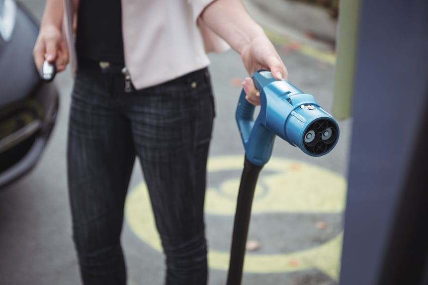 Frau lädt E-Auto
