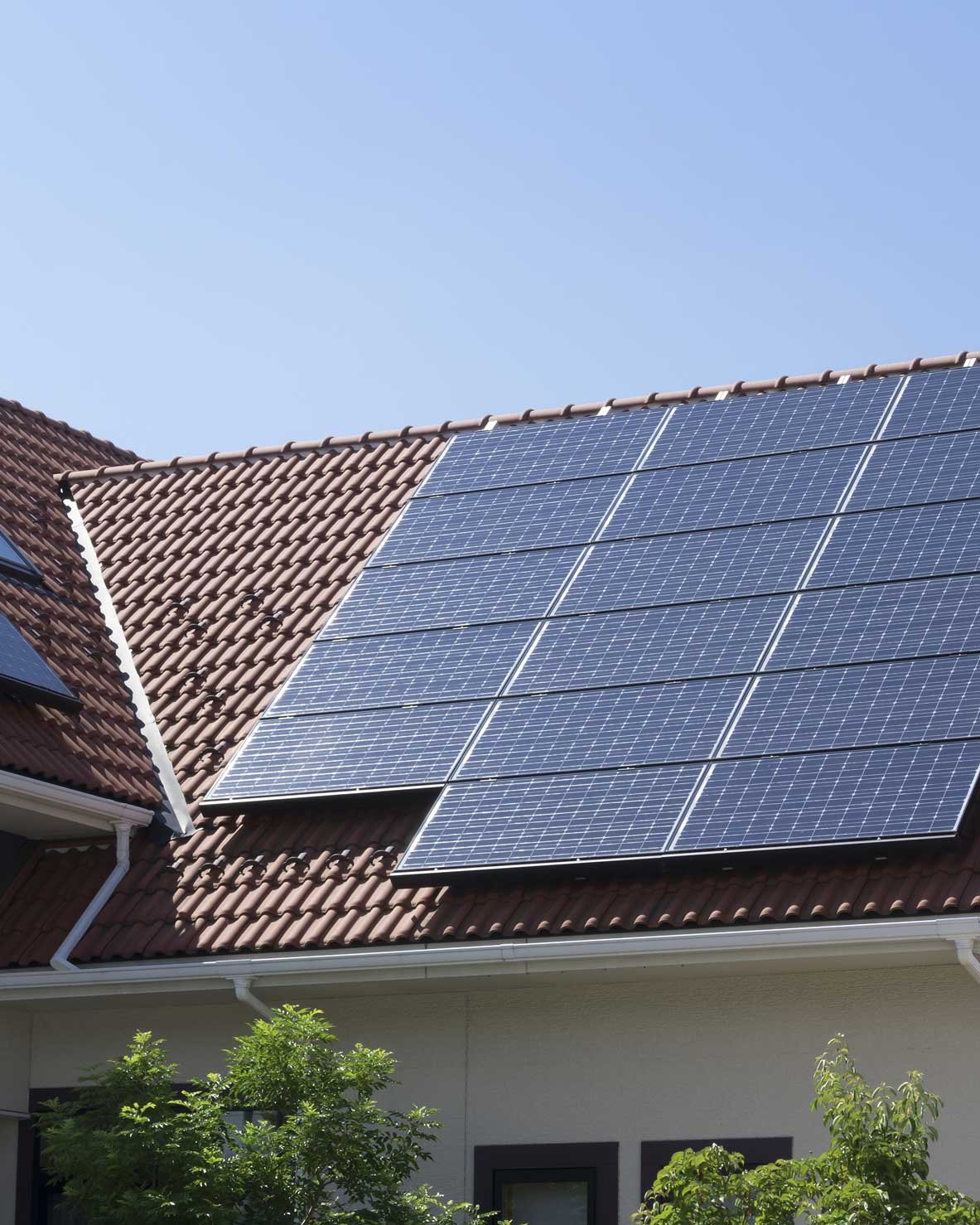 Photovoltaikpaneele auf dunkelrotem Schrägdach