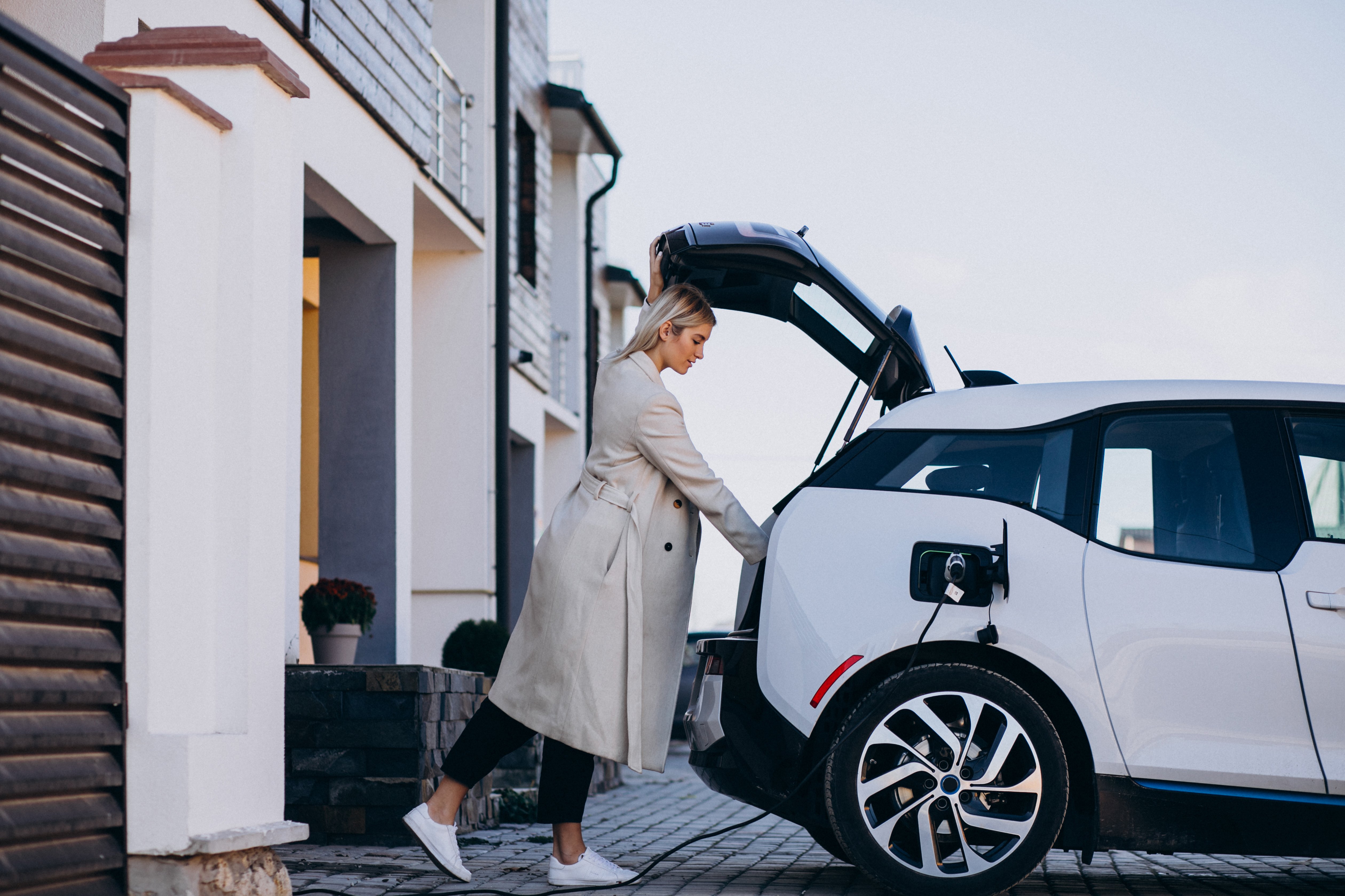 woman-charging-electro-car-by-her-house