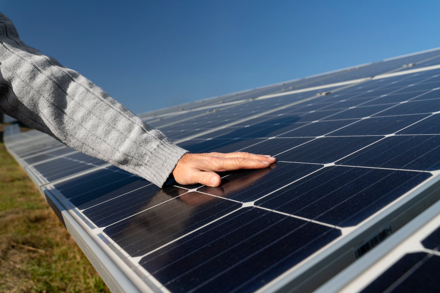 Person legt Hand auf Solarpaneele