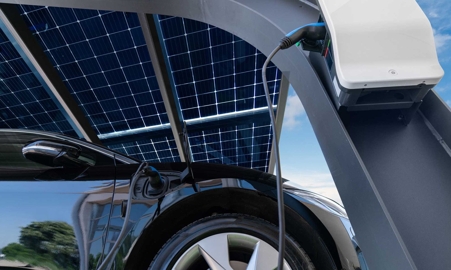 Schwarzes E-Auto steht unter Solar-Carport