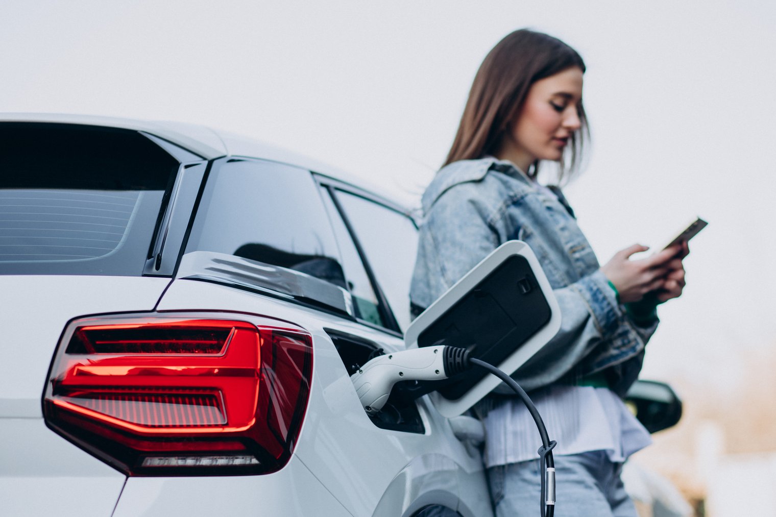 Frau lehnt an Elektroauto